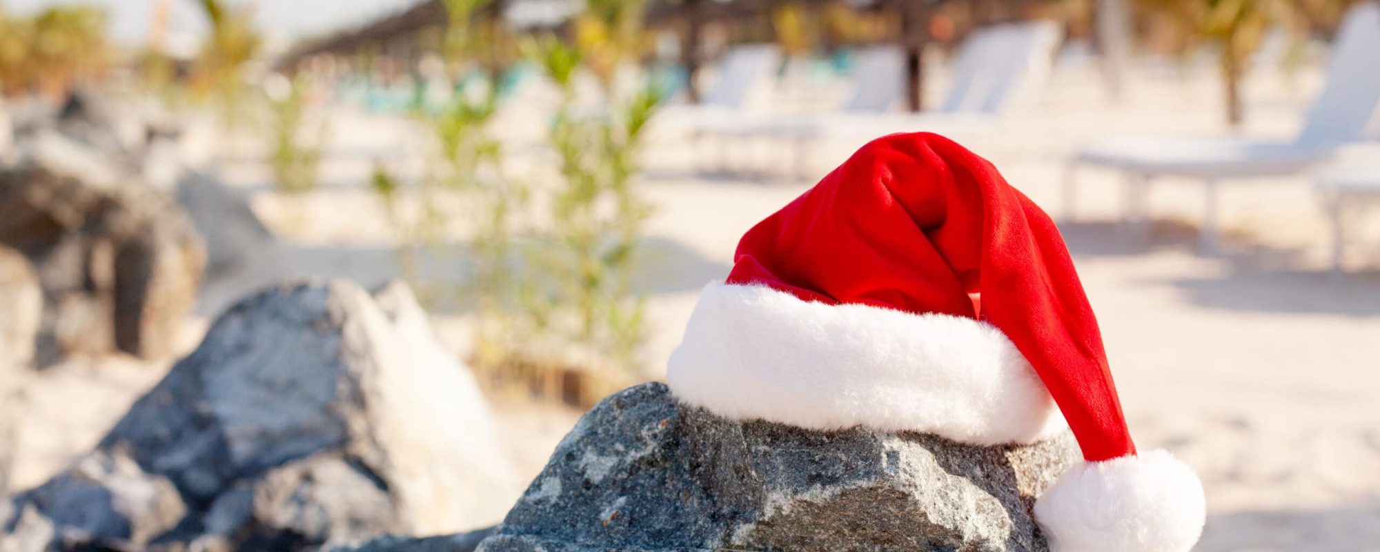 Santa hats on the beach. Christmas and New Year holidays in the concept of warm countries.